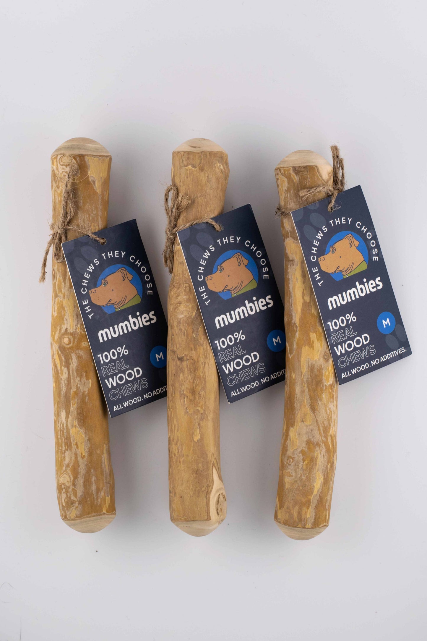 Three wooden chew sticks with 'mumbies' labels on a white background