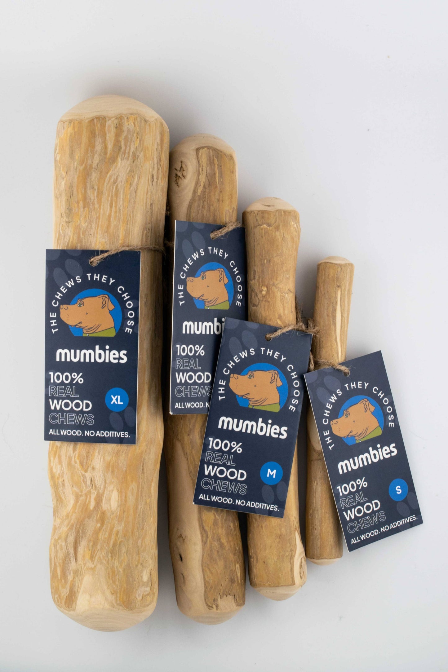 Wooden dog chew toys with packaging labeled 'mumbies' on a white background